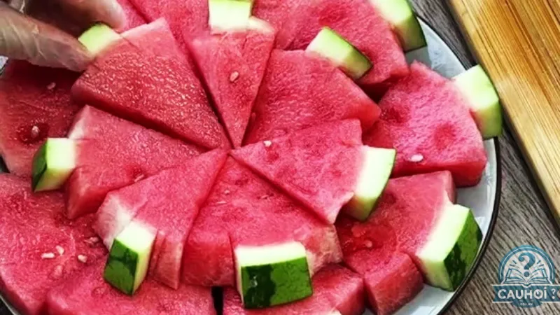 Bổ dưa hấu thành các miếng hình cây thông Bổ dưa hấu thành các miếng hình cây thông